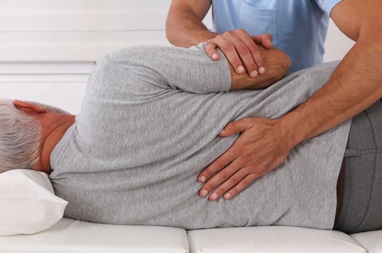 A chiropractor gently examines a patient's neck while the patient sits in a calm clinical setting.
